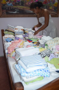 Ruth (one of the Malagasy Midwives) excited to organize the new clothes for these newest little ones! Each woman in the program gets a receiving blanket and an outfit once their baby is born.